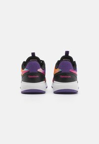 Chaussures de sport noires et violettes avec une tige en maille texturée, des accents colorés, une languette rembourrée et une semelle intermédiaire blanche dotée d'une semelle extérieure violette.