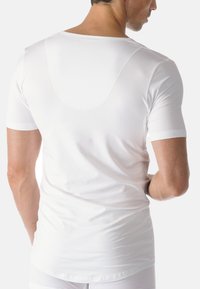 White short-sleeve t-shirt made from soft, stretchy fabric. Features a rounded back neckline and fitted design. Smooth texture with no visible patterns.
