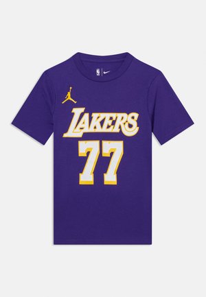 Fialové tričko Lakers se žlutým a bílým nápisem "LAKERS", bílým číslem 77 s žlutým obrysem a malým žlutým logem Jumpman na přední straně.