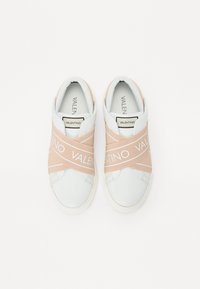 Baskets blanches avec des bandoulières élastiques rose pâle portant le texte "VALENTINO". Cuir lisse avec un bout arrondi et une semelle intérieure rembourrée.