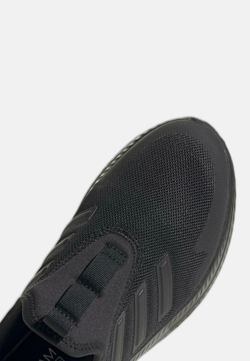 Zwarte instap sport schoen met een bovenwerk van mesh, drie matte strepen aan de zijkant en een gestructureerde zoolrand.
