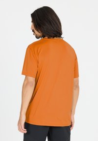 Kortärmad t-shirt med rund halsringning i orange, tillverkad av ett mjukt, lätt tyg. Har en avslappnad passform och platta sömmar för ökad komfort.