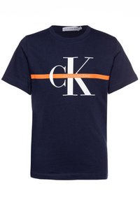 Námořnická modrá bavlněná tričko s velkým bílým logem "CK" a oranžovým horizontálním pruhem napříč hrudníkem. Klasický design s kulatým výstřihem.