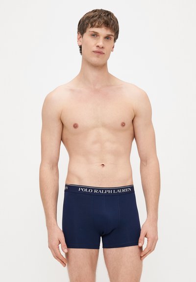 Tamsiai mėlyni vyriški bokseriai su prekinio ženklo elastine juosta. Pagaminti iš minkštos, tamprios medžiagos, klasikinio stiliaus.