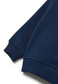 Polsini di felpa blu navy con texture a coste, caratterizzati da una finitura in tessuto liscia e dettagli di cucitura pulita.