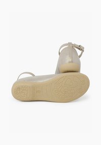 Sølvmetallic læder ballet flade sko med ankelrem, lav hæl og struktureret gummisål, der har hjerte- og blomster mønstre.