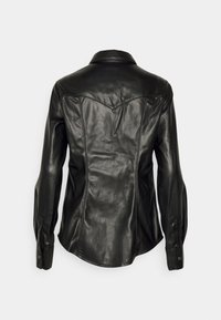 Chemise noire en cuir à manches longues avec empiècement style western et poignets boutonnés, vue de dos sur un fond uni.