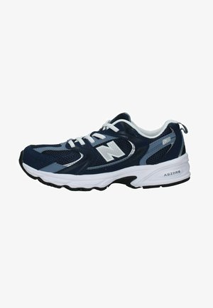 Chaussure de sport bleu marine avec une tige en maille, lacets blancs et semelle blanche épaisse. Présente un logo "N" et des détails "ABZORB" au niveau du talon.