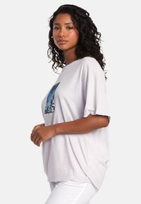 Jasnoszara, oversize t-shirt z krótkim rękawem, z kolorową grafiką palmy w prostokątnym wzorze z przodu.