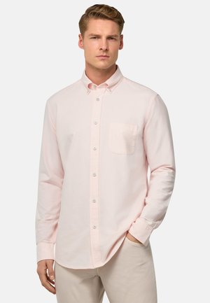 Camicia button-up a maniche lunghe rosa chiaro in morbido cotone, con una singola tasca sul petto, colletto standard e chiusura con bottoni.