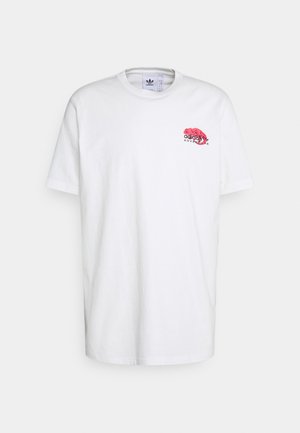 Weißes Adidas T-Shirt mit kurzen Ärmeln, mit kleinem rotem Chamäleon-Grafik und dem Schriftzug „adidas adventure“ oben links auf der Brust.