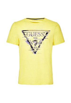 Gelbes T-Shirt mit kurzen Ärmeln und verzerrtem schwarz-weißem GUESS USA Dreieck-Logo und Fragezeichen auf der Vorderseite.
