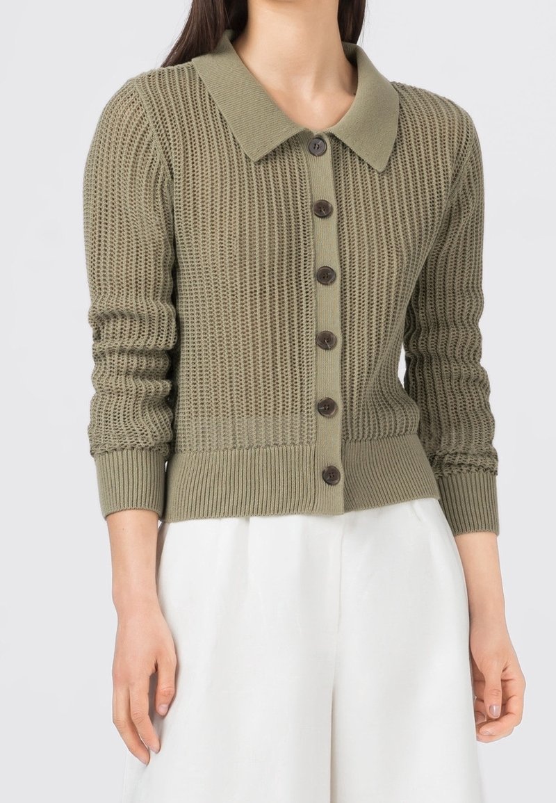 Olivgrön stickad cardigan med krage, knappstängning framtill, ribbade manschetter och en strukturerad mönster över hela.