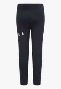 Leggings sportivi blu navy con una texture liscia, dotati di un alto passante in vita e di una scritta bianca sul lato. Tessuto elastico per il massimo comfort.