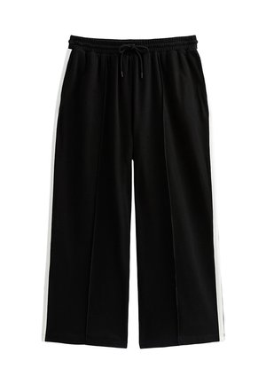 Pantalons larges noirs avec une taille élastique et un cordon de serrage. Dotés de rayures blanches sur les côtés et d'une texture de tissu lisse.