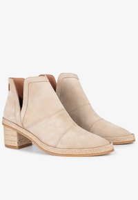 Botas de tobillo de ante beige con puntera puntiaguda, paneles laterales de elastano y tacón de yute trenzado. El diseño presenta detalles de costura en la parte superior.