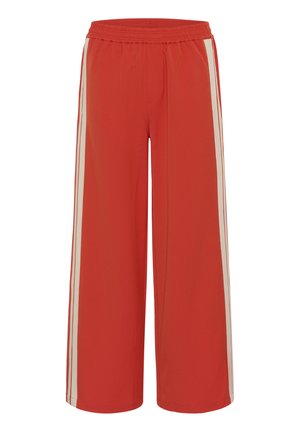 Punased laiad püksid elastse vöörihma ning valgete küljestriipudega jalgadel, valmistatud siledast kangast.