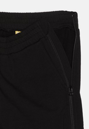 Schwarze Stoff-Jogginghosen mit elastischem Bund und einer seitlichen Reißverschlusstasche; glatte Textur, minimalistisches Design.