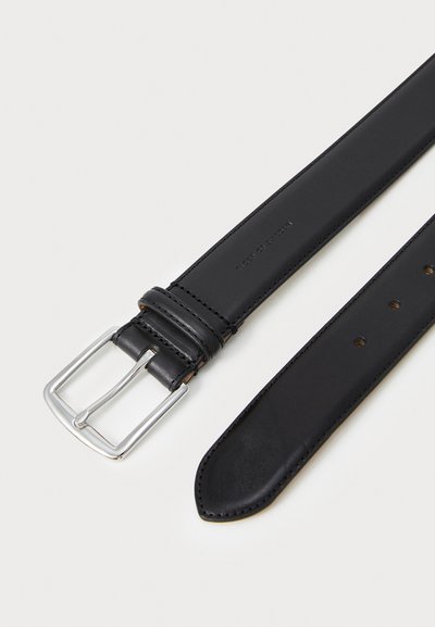 Cinturón de cuero negro con una textura suave, que presenta una hebilla rectangular plateada y múltiples agujeros de ajuste a lo largo de la correa.