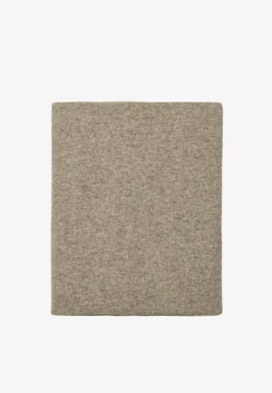 Écharpe en laine tricotée beige carrée pliée sur fond blanc montrant la texture et la matière douce.