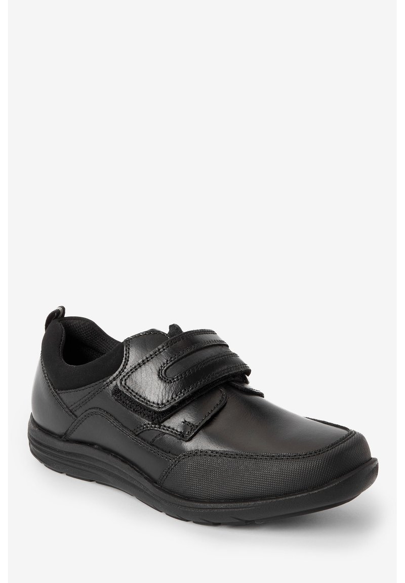 Chaussures de sport noires en matériau synthétique, arborant une texture lisse, un système de fermeture avec bande Velcro, et un col rembourré pour plus de confort.
