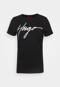 Musta lyhythihainen T-paita, jossa on käänteiset hihat ja valkoinen käsinkirjoitettu "Hugo" -logo rinnassa yksinkertaisella taustalla.