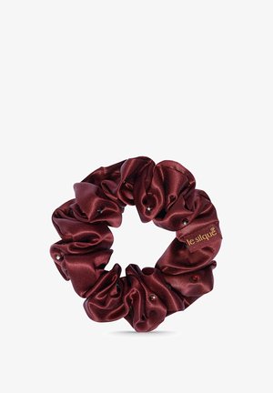Bordeaux satijnen haarscrunchie met een gerimpeld design, voorzien van kleine decoratieve kralen en een merklabel. Cirkelvormig, glad van textuur.