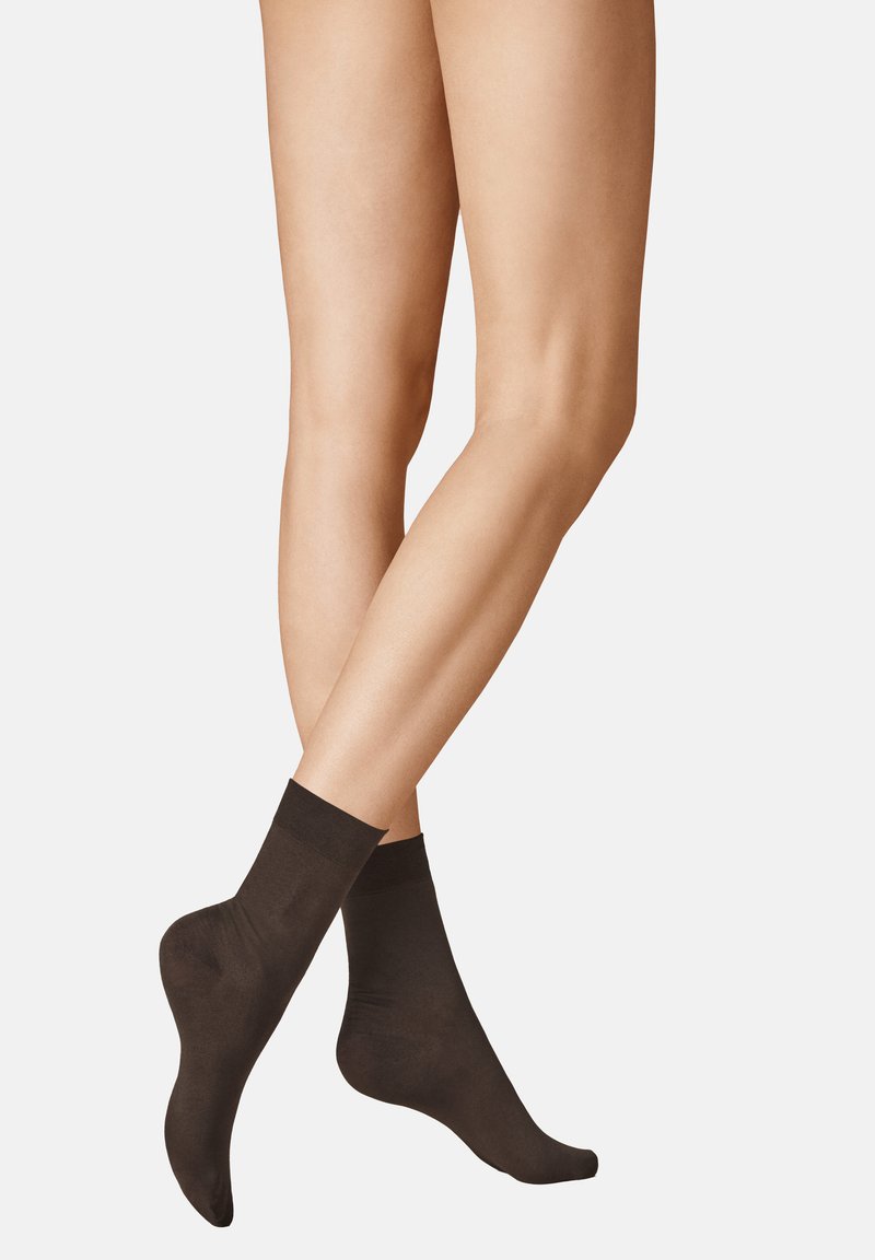 Schwarze Knöchelsocken aus glattem Material, mit einem gerippten Bund und einer figurbetonten Silhouette, die auf zwei schlanken Beinen positioniert sind.