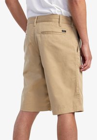 Khaki shorts lavet af en bomuldsblanding, med bæltestropper, to baglommer og et lille logo på livet, glat tekstur, knælængde.