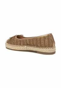 Zapato tipo espadrille con parte superior de fibra trenzada en marrón, abertura elástica y suela de yute trenzado en contraste. Presenta un lazo decorativo en la parte frontal.
