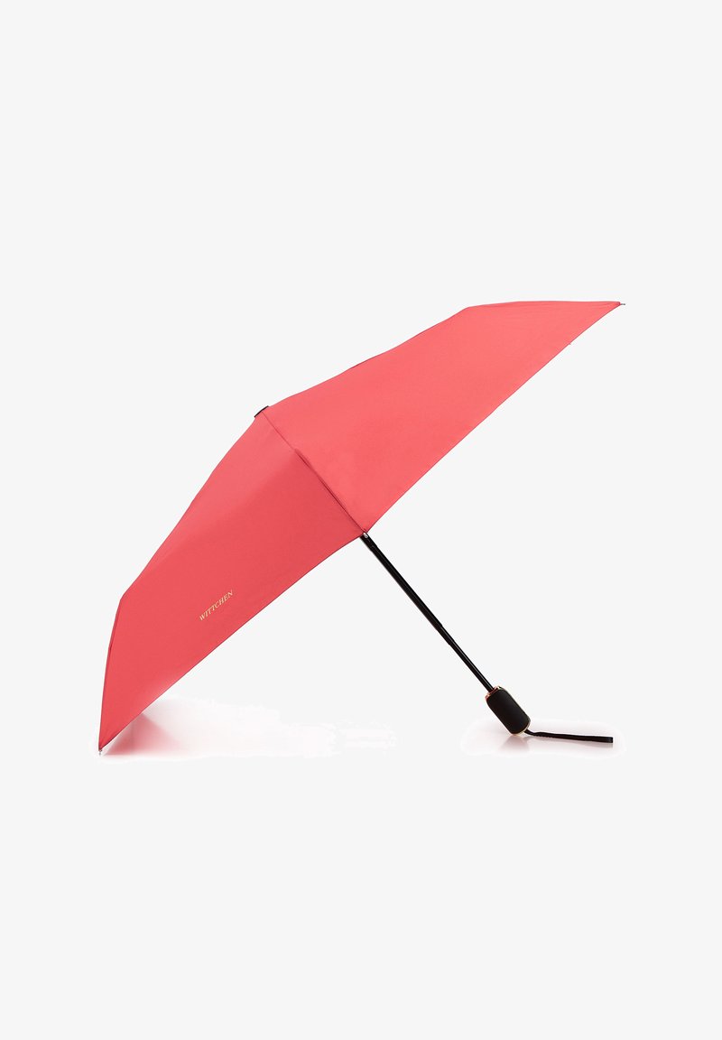 Coral umbrella with a sleek, curved shape. Black metal frame and handle, featuring a strap for easy carrying. Brand name in gold lettering.