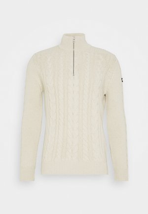 Pull en tricot de couleur crème avec un col montant et une demi-fermeture éclair. Présente un motif en tricot torsadé et des poignets et ourlet côtelés.