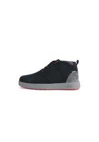 Stivaletti alla caviglia in suede blu scuro con accenti grigi e una suola in gomma rossa, caratterizzati da lacci e un design cucito sulla parte superiore.