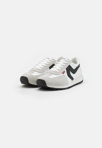Herrensneaker in Grau und Weiß, aus einer Mischung von Wildleder und synthetischem Material, mit Schnürsenkeln und einem schwarzen Akzent-Swoosh. Gummiaußensohle.