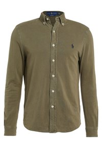 Camicia verde oliva a maniche lunghe con bottoni, realizzata in tessuto morbido, con colletto, bottoni bianchi e un piccolo logo blu navy sul petto.