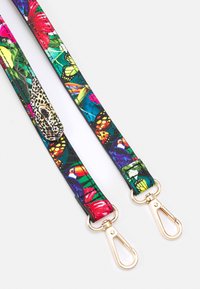 Deux sangles en tissu colorées avec des clips en métal doré, comportant des imprimés tropicaux de toucans, papillons et un léopard sur fond blanc.
