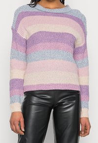 Pull en maille avec rayures pastel en lavande, rose et bleu clair, doté d'une encolure large et de poignets côtelés. Assorti à un pantalon en cuir noir.
