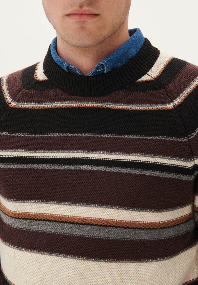 Maglione a righe con tonalità di marrone, nero e crema. La texture a maglia presenta un colletto a coste e righe orizzontali a contrasto.
