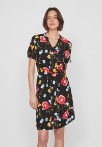 Abito floreale nero con maniche corte, bottoni frontali, vita con cintura e motiffe floreale con fiori rossi, gialli e blu.