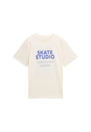 Krējuma krāsas kokvilnas t-krekls ar uzrakstu "SKATE STUDIO" treknā zilu burtu stilā un papildu tekstu zem tā. Īsas piedurknes un apaļa kakla izlases forma.