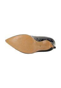 Scarpa nera con punta a punta, caratterizzata da una texture in rilievo a forma di coccodrillo, un design elegante e una suola beige liscia con scanalature orizzontali per migliorare la trazione.