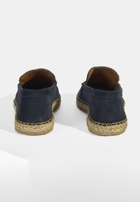 Marine blauw suede instappers met een gevlochten jute zool, met een ronde neus en zichtbare stiksels langs de naad.