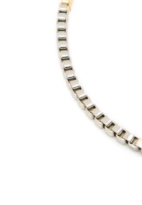 Pulsera de metal plateado con eslabones rectangulares y un cierre dorado. Textura suave con un acabado pulido, mostrando formas de eslabones alternantes.