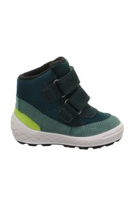 Groene en blauwe suède enkellaarsjes met twee zwarte klittenbandsluitingen, witte rubberen zool en een limegroene accent op de hak. Geprofileerde afwerking.