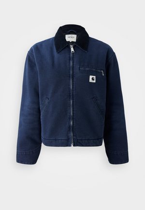 Navy blue zip-up jacket with black collar, two front pockets, chest zipper pocket, and small Carhartt logo patch on left chest.