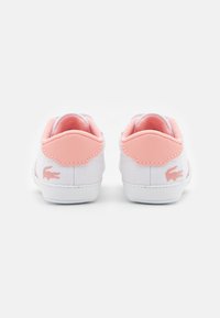 Weiße Leinenschuhe mit pinken Lederakzenten, ausgestattet mit einer strukturierten Rückseite und einem kleinen pinken Logo. Glatte Sohle und gepolsterter Kragen für Komfort.