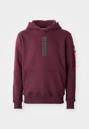 Mörk röd hoodie med framficka, vertikalt "ALPHA"-logga på bröstet och en dragkedjeficka med röd tagg på vänster ärm.