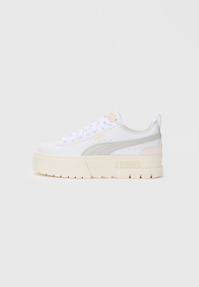 Scarpa sportiva bianca con accenti grigi, dotata di una suola spessa e texturizzata e collo imbottito. Lacci e dettagli del logo in evidenza.