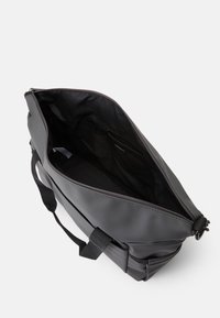 Saco tote preto feito de material texturizado e impermeável. Apresenta um interior espaçoso com fecho de correr e dois cabos robustos.