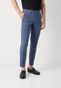 Modré upravené kalhoty s hladkým povrchem, slim fit, přední kapsy a zapínání na jeden knoflík, doplněné černými mokasíny.
